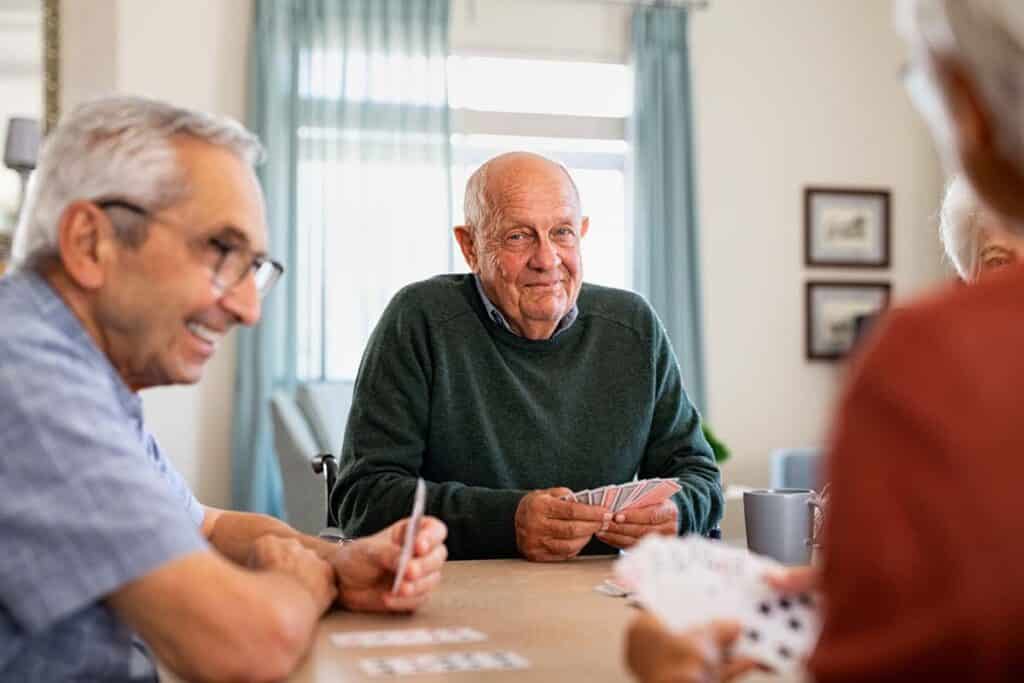 Barton House Memory Care | Joyful senior friends playing cards together