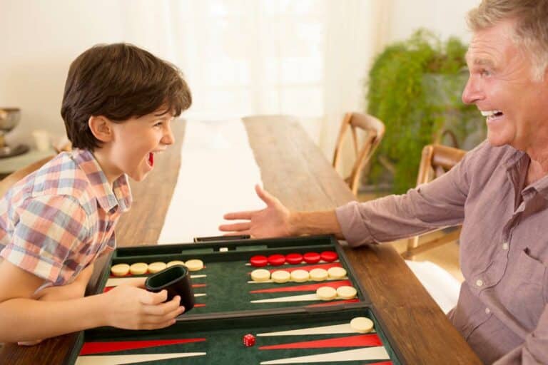 Barton House Memory Care | Senior man playing backgammon with son
