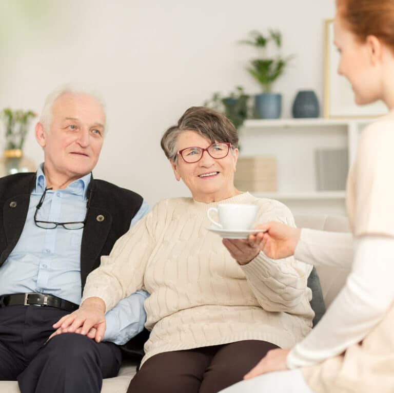 Barton House | Senior couple talking with caregiver