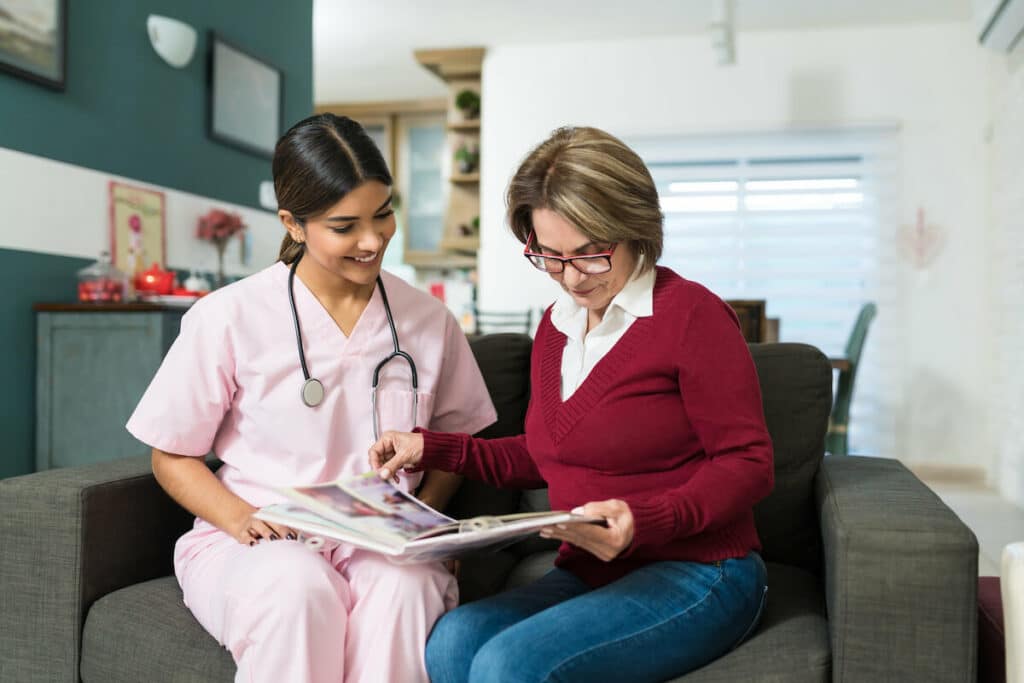 Barton House Memory Care | Senior woman sitting with her caregiver going over paperwork