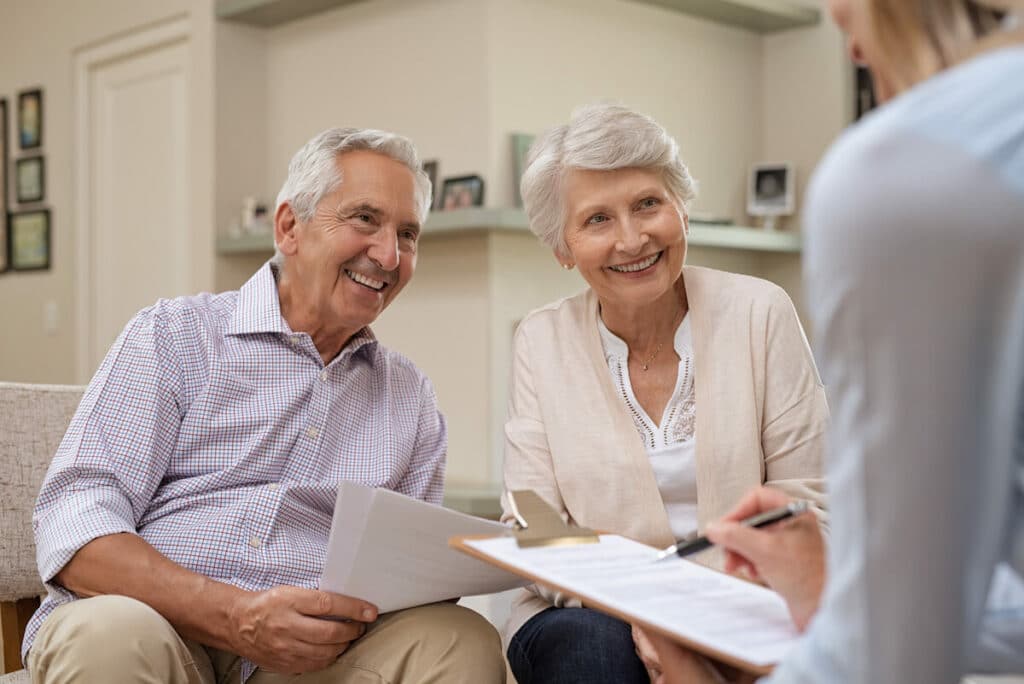 Barton House Memory Care | Senior couple sitting down going over paperwork with a professional