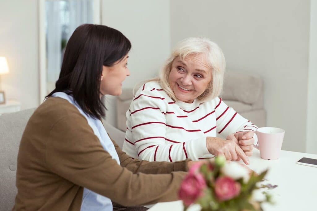 Barton House | Senior woman smiling with her caregiver