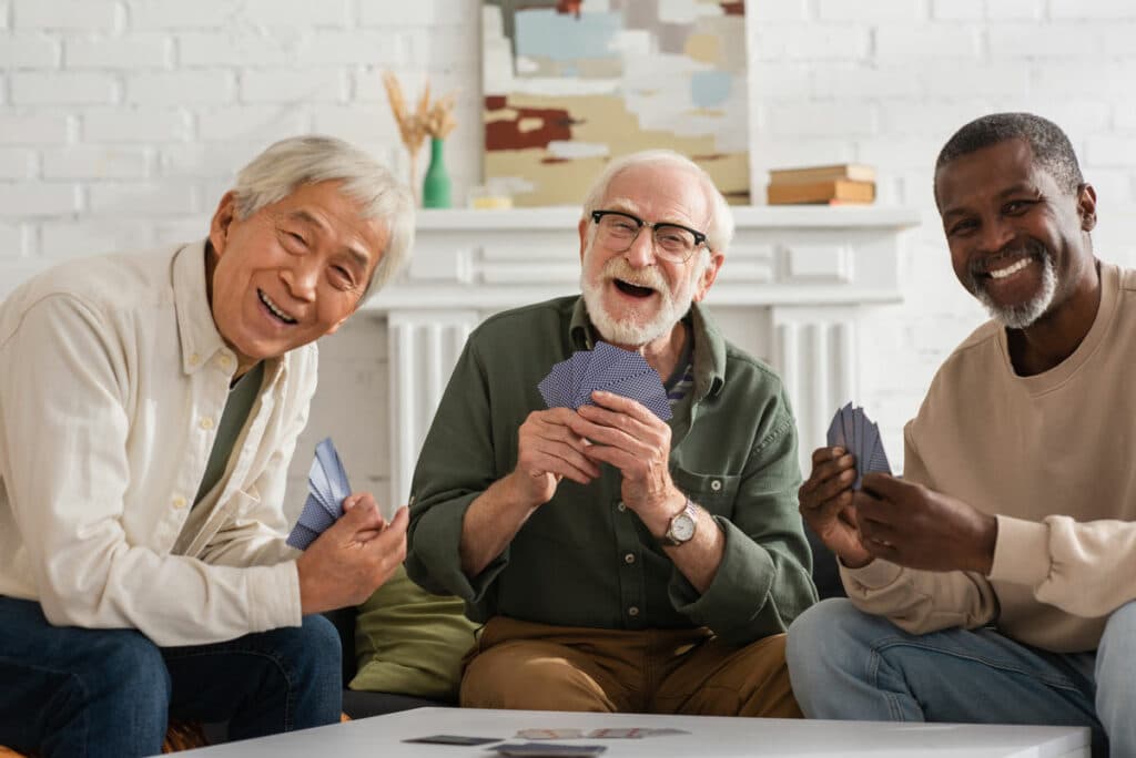 Barton House Memory Care | Happy seniors playing a game of cards