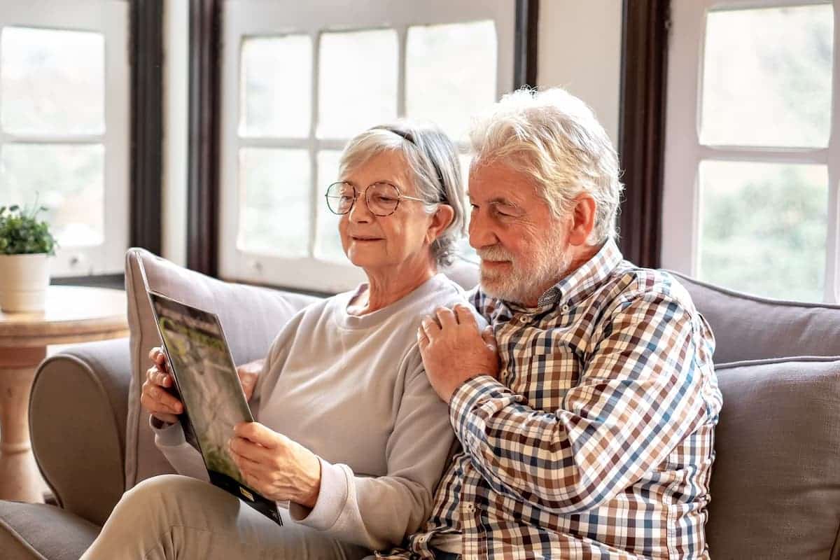 Barton House | Senior couple looking at new together on the sofa