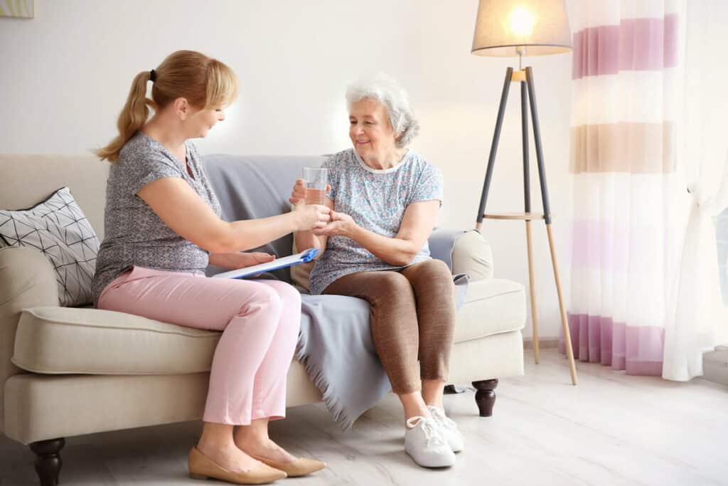 Barton House | Caregiver giving senior woman medication