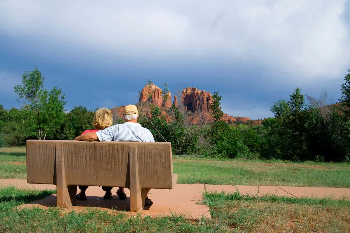Barton House | Retired senior couple sitting on a bench in front of an Arizona mesa