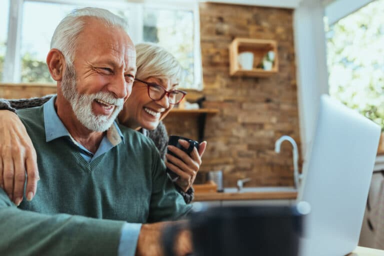 Novellus Cypresswood | Senior couple laughing and smiling at their computer