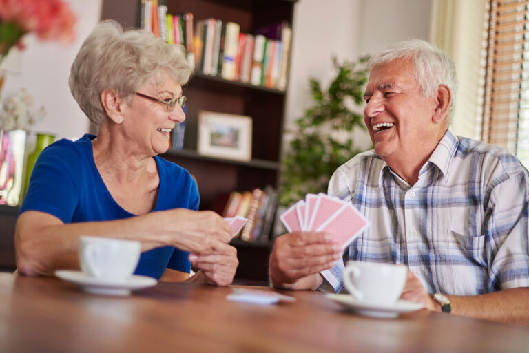 Novellus Kingwood | senior couple playing cards together and laughing