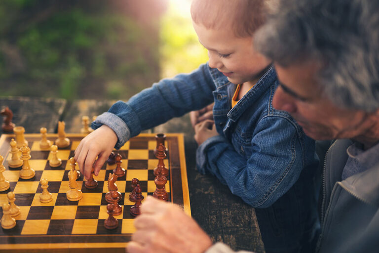 Novellus Kingwood | Senior man playing chess with grandson