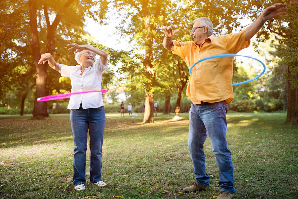 Novellus Kingwood | Senior man and senior woman hula hooping