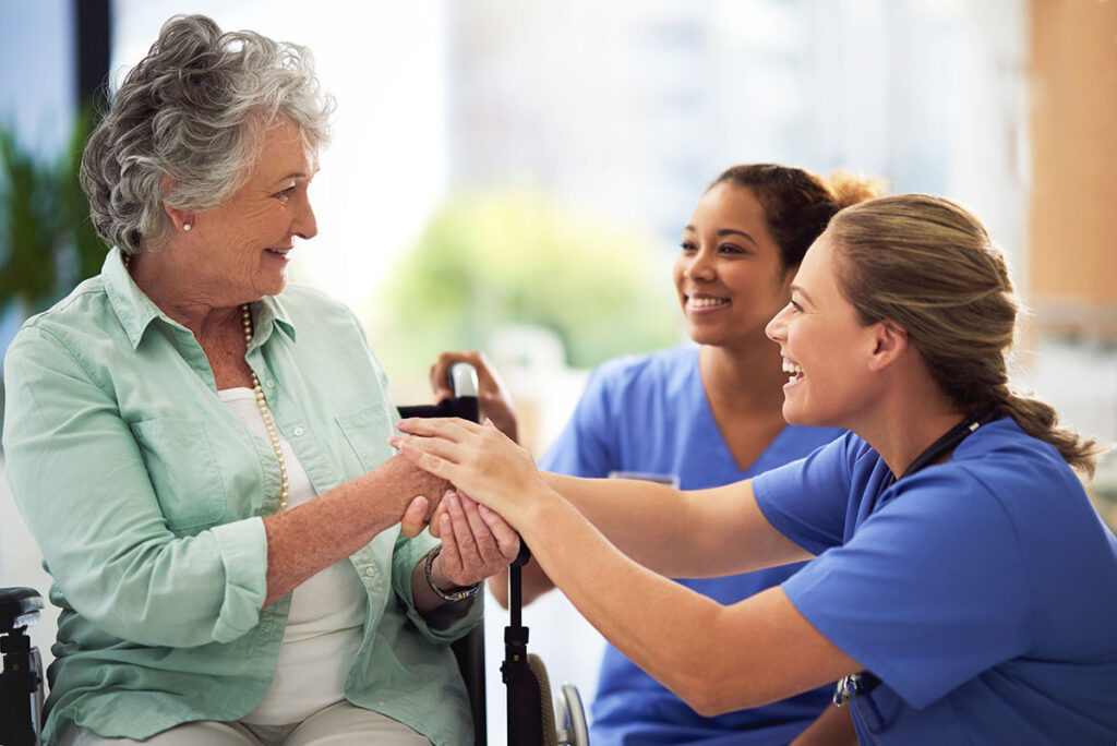 Novellus Kingwood | Shot of a smiling female doctor and nurse talking with a senior woman in a wheelchair