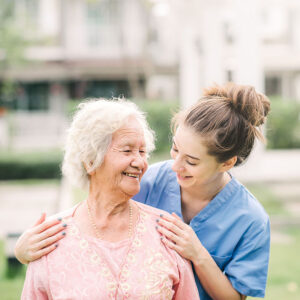 Novellus Kingwood | Smiling nurse caregiver with Asian elderly woman outdoor in the park