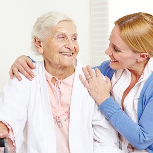 Novellus Kingwood | Senior woman with cane sharing happy moment with caretaker