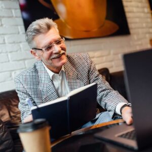 Orangeburg Memory Care | Senior man in a suit reading and working on a computer