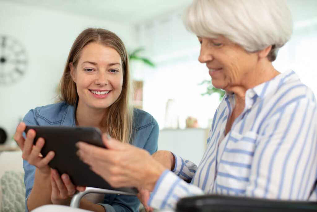 Orangeburg Memory Care | Senior woman looking at a tablet with her caretaker