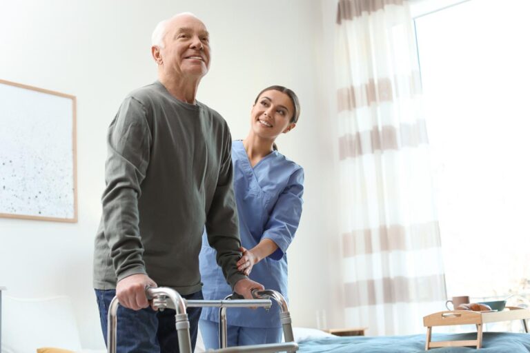Stockton Assisted Living | Care worker helping elderly man with walker in geriatric hospice