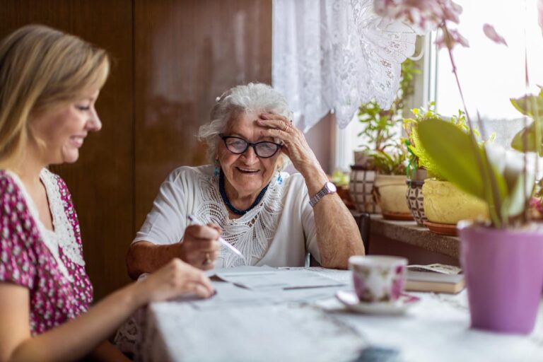 Stockton Assisted Living | Senior smiling reading documents