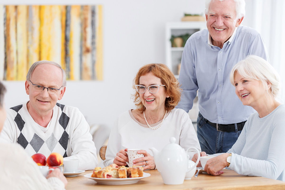 Stockton Assisted Living | Group of happy seniors socializing around a table