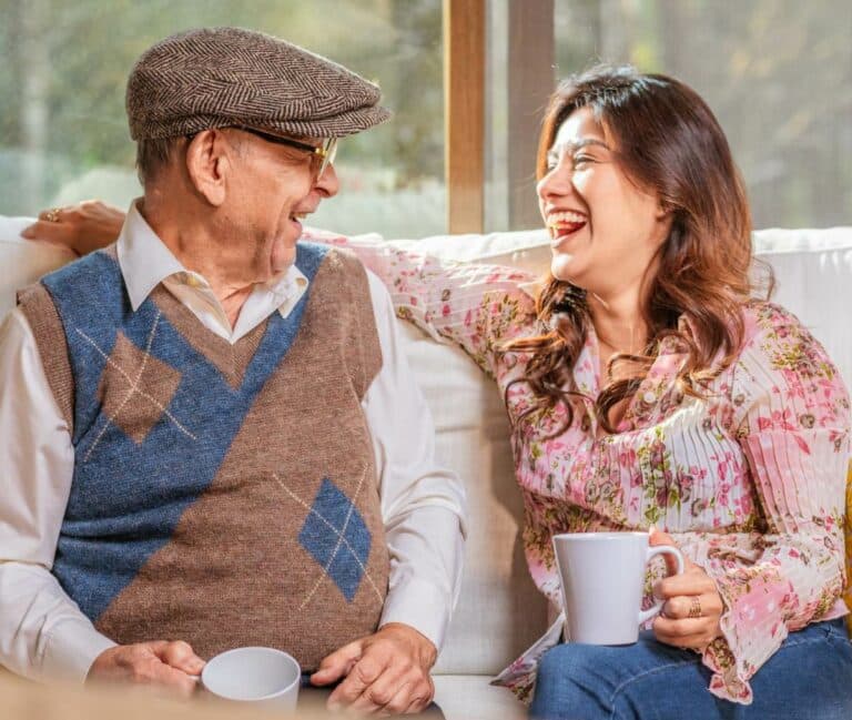 Stockton Assisted Living | Senior man and caregiver having coffee and laughing