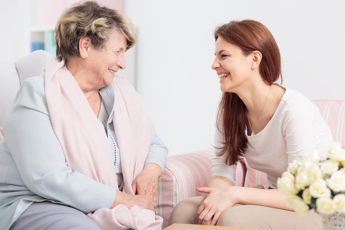 Novellus | Happy senior and caregiver laughing together
