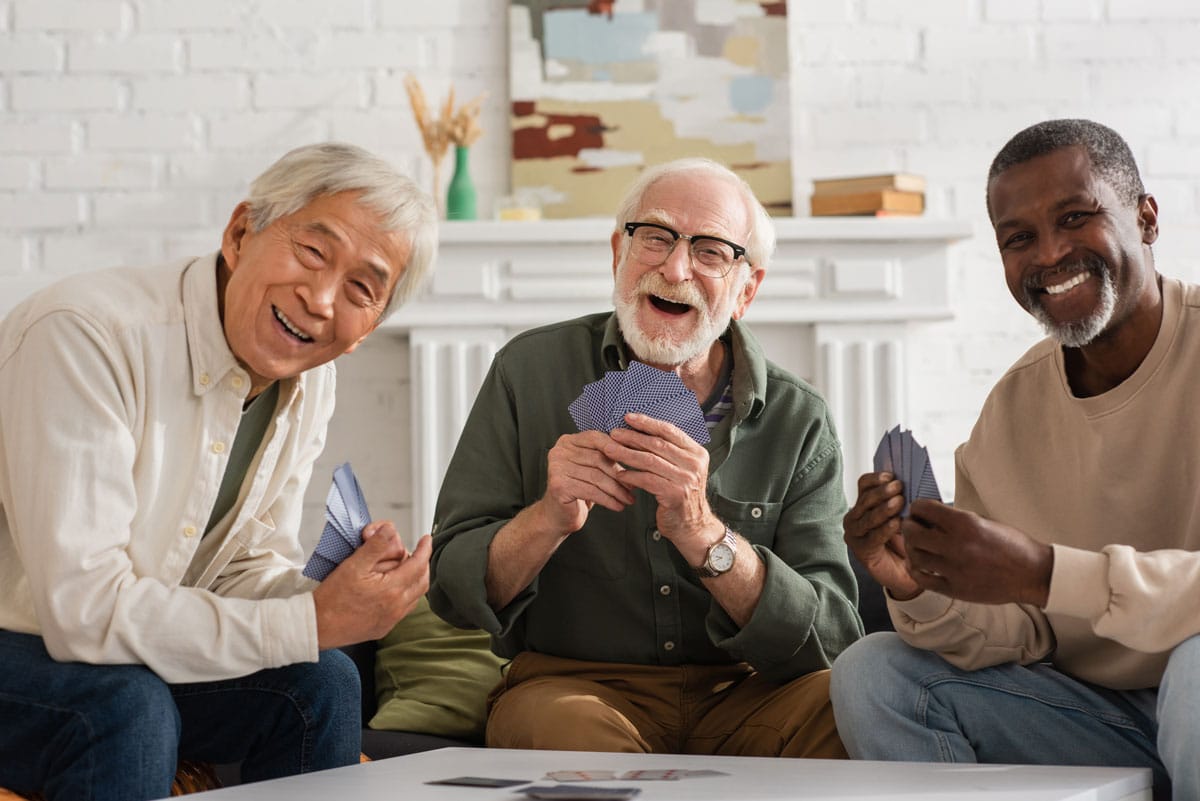 Barton House Memory Care | Happy seniors playing a game of cards