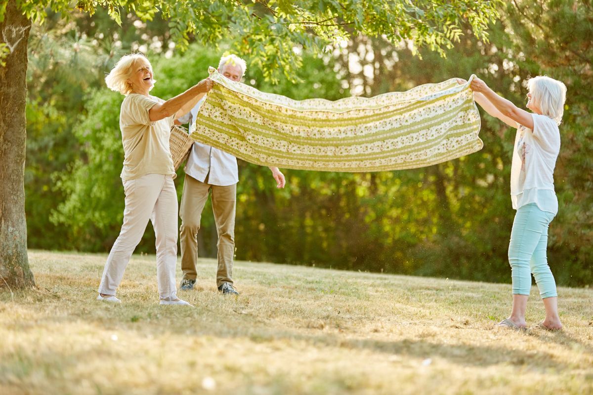 Novellus Cherry Creek | Group of seniors setting a picnic blanket outside