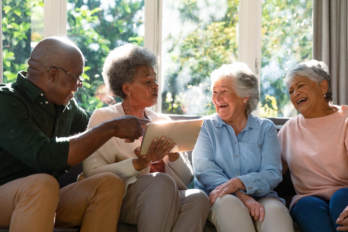 Novellus Cypresswood | Seniors sitting on the sofa sharing and laughing